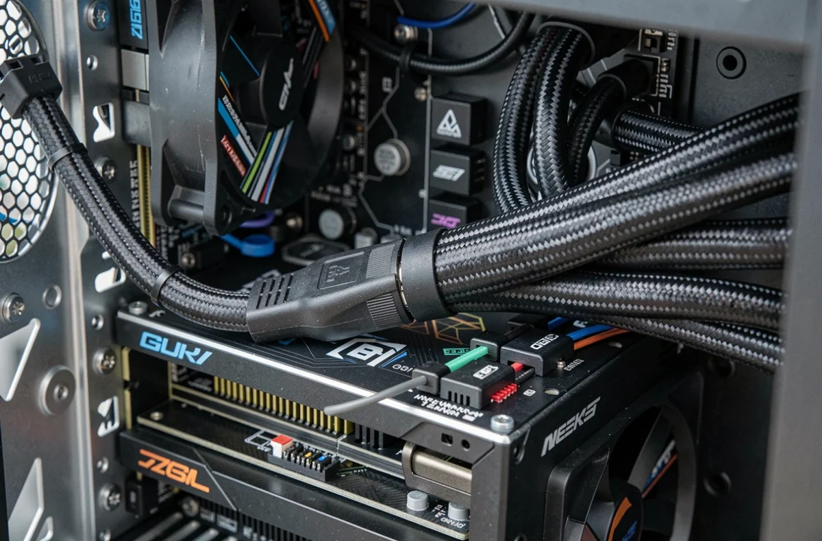 Gros plan sur un connecteur de câble d'alimentation inséré dans un bloc d'alimentation PC à l'intérieur d'un boîtier gaming vitré